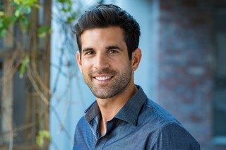 Handsome mid adult man smiling and looking at camera. Portrait o