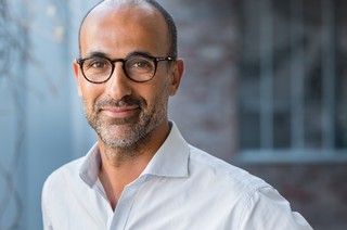Portrait of happy mature man wearing spectacles and looking at c